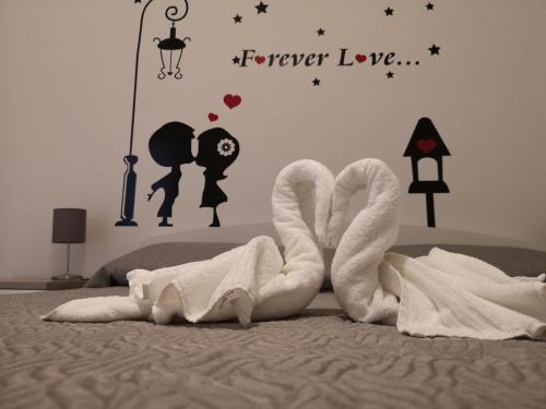 卡塔尼亚mungiBEDdu Apartment的一张带两条毛巾的床和一个永远爱读的标语