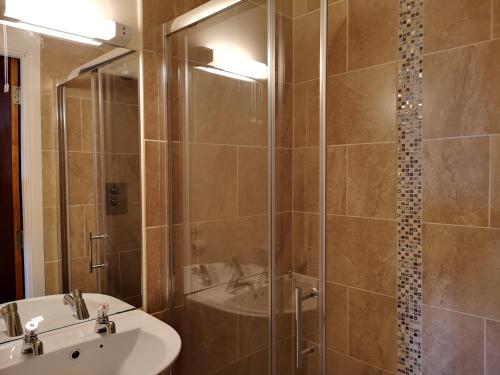 班多伦邦克之家宾馆的带淋浴、盥洗盆和浴缸的浴室