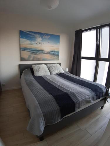 米兹多洛杰Horyzont 201的卧室内的一张床铺,设有大窗户