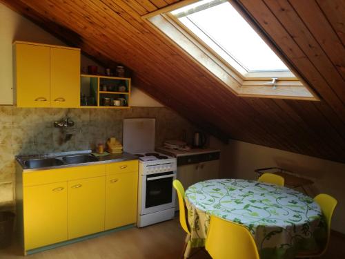 布德瓦Guest House Vila Bak的厨房配有桌子、黄色橱柜和窗户