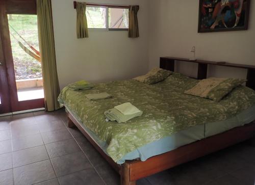 MalenaHotel Heliconia Panamá的一间卧室配有一张带绿色棉被的床