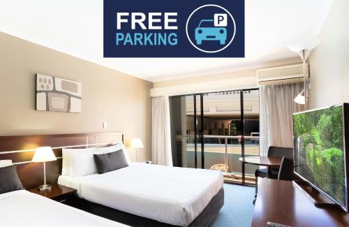 布里斯班Riverside Hotel Southbank的酒店客房设有两张床,并标有可免费停车的标志。