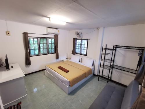 拉迈满月苏梅之家酒店的一间卧室设有一张床和两个窗户。