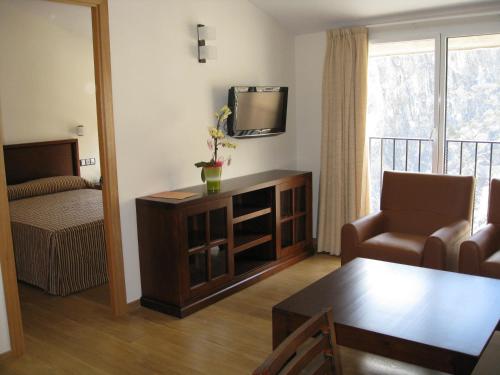 卡尼略奥巴卡布兰卡SPA公寓式酒店 的客厅配有电视、椅子和桌子
