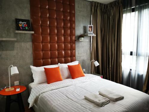 莎阿南Studio Apartment with Balcony by Host Assist i-City的一间卧室配有一张带橙色枕头的大床