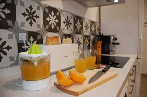 科尔多瓦ALHAJAS DE CORDOBA的厨房柜台在切板上放有橙汁杯