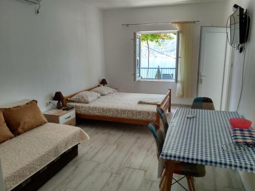帕里斯特Apartments Jovanović的客房设有两张床、一张沙发和一张桌子。
