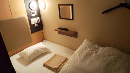 和歌山Guesthouse kukuru的一间卧室配有一张床,床上有毛巾