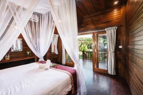 蓝梦岛The Cozy Villas Lembongan的卧室配有白色窗帘的床