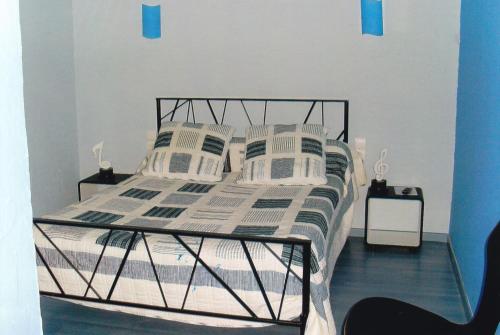 内拉克chambre d'hotes a nérac的一间卧室配有一张带黑色框架和枕头的床。