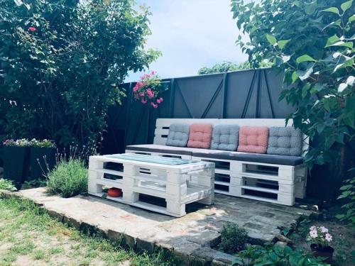 贝尔格莱德MARE Apartmant的花园内带枕头的白色长凳