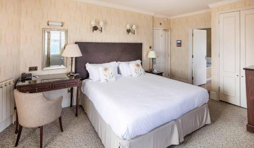 圣欧班多兰萨莫维尔酒店的卧室配有一张白色大床和一张书桌