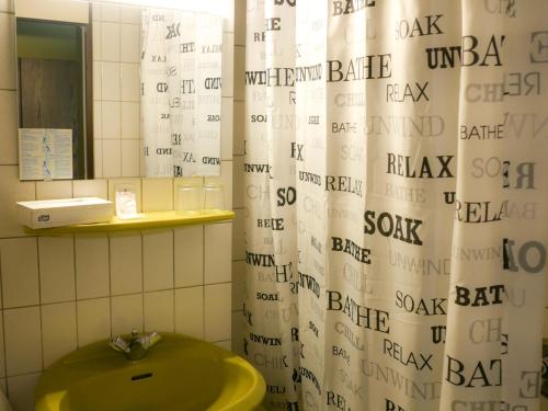 科布伦茨Hotel Oronto的浴室配有淋浴帘和绿色水槽。