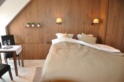 ZandvoordeB&B Cottage Sandfort的一间卧室配有一张大床和一张带椅子的桌子
