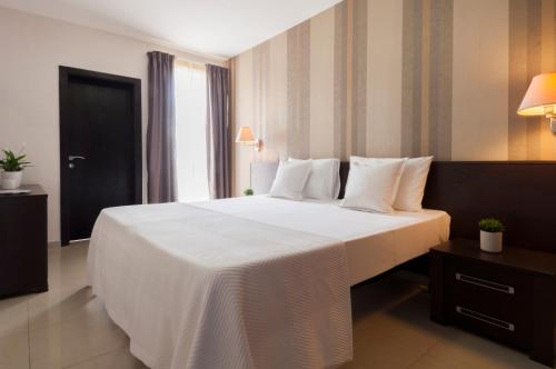 埃尔哥茨拉Blubay Apartments by ST Hotels的卧室配有一张带白色床单和枕头的大床。