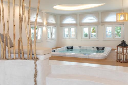 圣安娜纳克索斯Cycladic Islands Hotel & Spa的带窗户的客房内的按摩浴缸