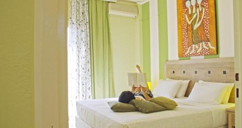 卡拉塔斯睡莲酒店式公寓的卧室配有一张床,卧室内有一个人躺在床上