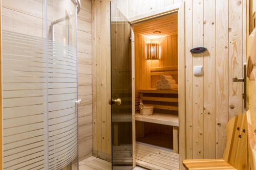 考斯赛力克Domy Sywarne z Sauną i widokiem na góry的木制浴室内带玻璃门的淋浴