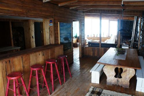 法洛伦斯Cordillera Hostel的一间酒吧,在一间房间里设有四张红色凳子