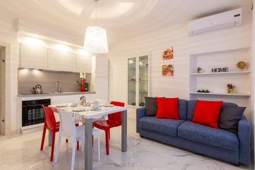 阿科Residenza San Rocco的客厅配有蓝色的沙发和带红色枕头的桌子