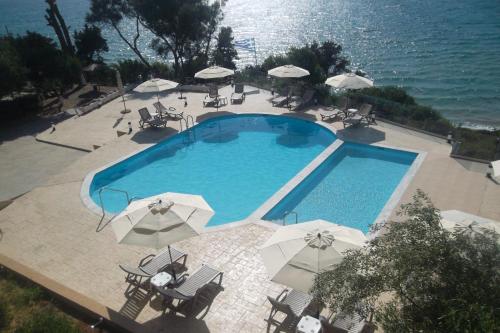 基利尼Kastro Beach Hotel的享有带遮阳伞的游泳池的顶部景致