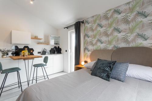 赫瓦尔Hvar Top View Apartments的一间卧室配有一张床铺和一张桌子,还设有一间厨房