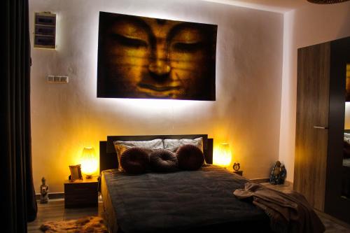 布加勒斯特Nirvana Apartament的一间卧室,配有一张带面部绘画的床