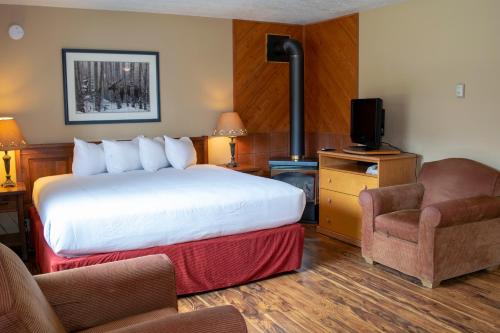 沃特顿公园阿斯彭村庄酒店的配有一张床和一把椅子的酒店客房