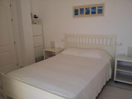 卡沃内拉斯Apartamento Vistas Espectaculares al Mar的卧室配有白色床罩和白色床罩