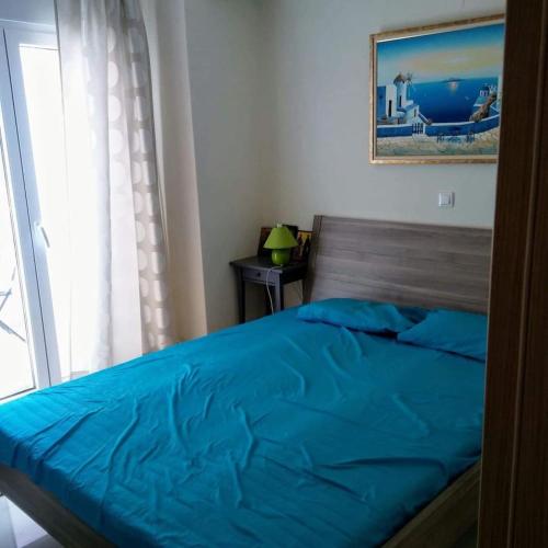 卡利塞亚-豪客迪克斯Cozy 1 bedroom apartment with a view to the pool close to the beach!的一间卧室配有一张带蓝色床单的床和一扇窗户。