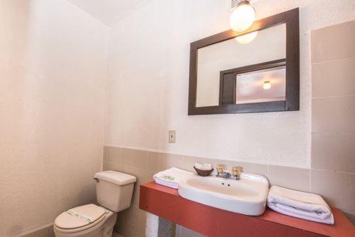 提华纳Hotel Descanso Inn的一间带水槽、卫生间和镜子的浴室