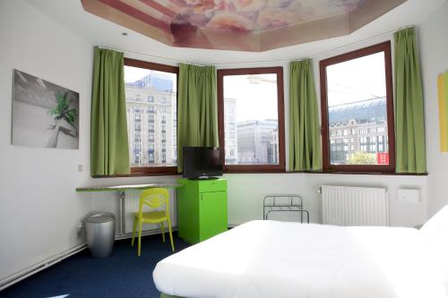 布鲁塞尔锡鲁尔酒店的一间卧室配有绿色窗帘和一张床及窗户