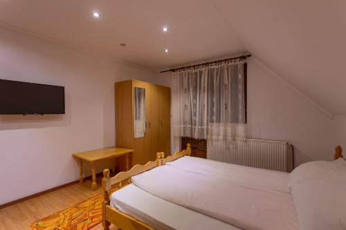 兹拉蒂博尔Vila Slavica的一间卧室配有两张床和一台平面电视