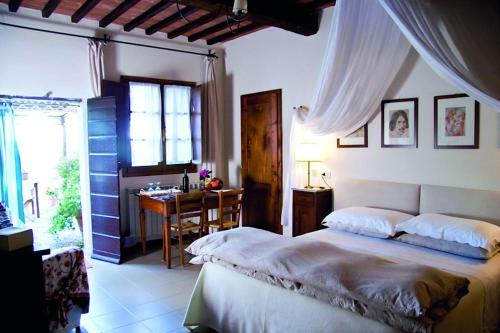 皮恩扎Le Traverse的一间卧室配有一张床、一张书桌和一个窗户。
