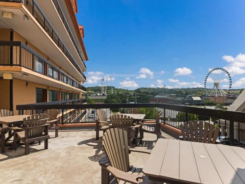鸽子谷Mountain Vista Inn & Suites - Parkway的阳台配有桌椅和摩天轮