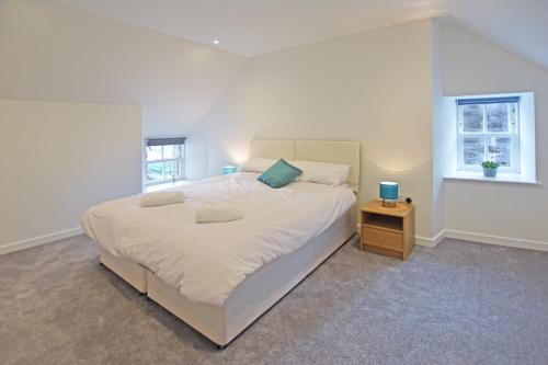 勒威克Modern Commercial Street Maisonette的一间卧室配有一张白色大床和床头柜