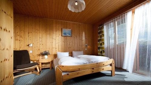 贝特默阿尔卑阿尔福莱顿酒店的卧室配有床、椅子和窗户。