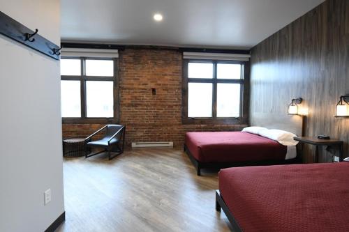 CrosbyCrosby Lofts的一间卧室设有两张床和砖墙