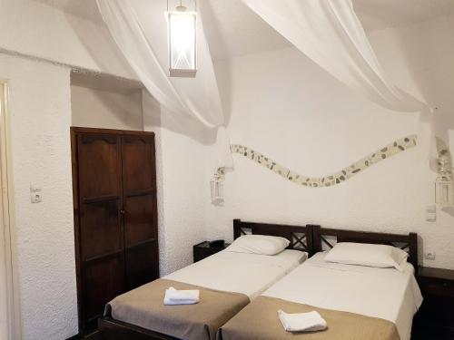卡罗维西阿尼玛海滨旅馆的白色客房的两张床,设有窗户