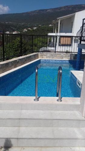 卢什蒂卡Apartments Bellavista的一座带楼梯的游泳池,位于房子旁边