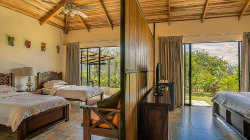 福尔图纳La Finca Lodge的一间卧室配有两张床和吊扇