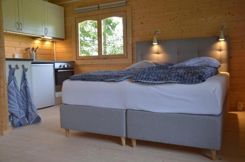 艾特韦Brakkerhus的木制客房内的一间卧室配有一张大床