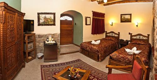 库斯科玛奎塞斯酒店的一间酒店客房,设有两张床和电视