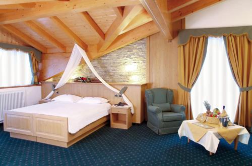 迪马罗Hotel Gran Vacanze Rooms & Apartments的一间卧室,卧室内配有一张床和一把椅子