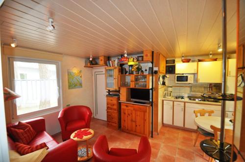 奥斯特西巴德钦诺维茨波罗的海畔度假屋的厨房配有红色的沙发和红色的椅子