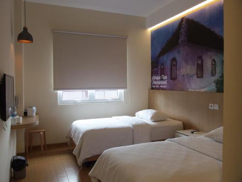 安汶城市酒店的酒店客房设有两张床和窗户。