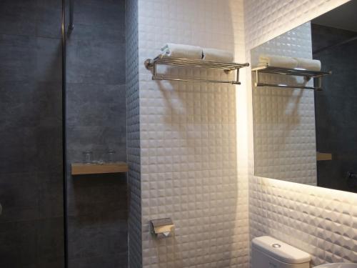 安汶城市酒店的一间带卫生间和玻璃淋浴间的浴室
