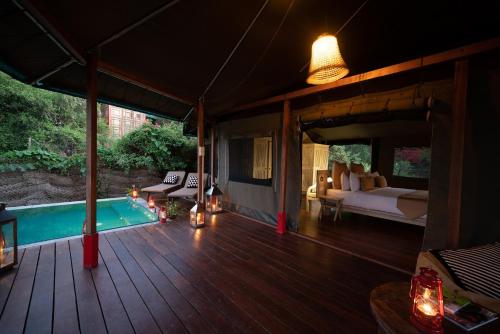 蒂瑟默哈拉默Flameback Eco Lodge的一个带床和游泳池的帐篷门廊