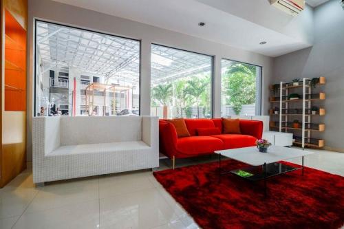 BonorejoRedDoorz near Solo Square 3的客厅配有红色沙发和红色地毯