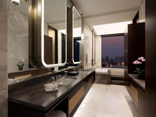 首尔Grand Mercure Ambassador Hotel and Residences Seoul Yongsan的一间带两个盥洗盆和大镜子的浴室